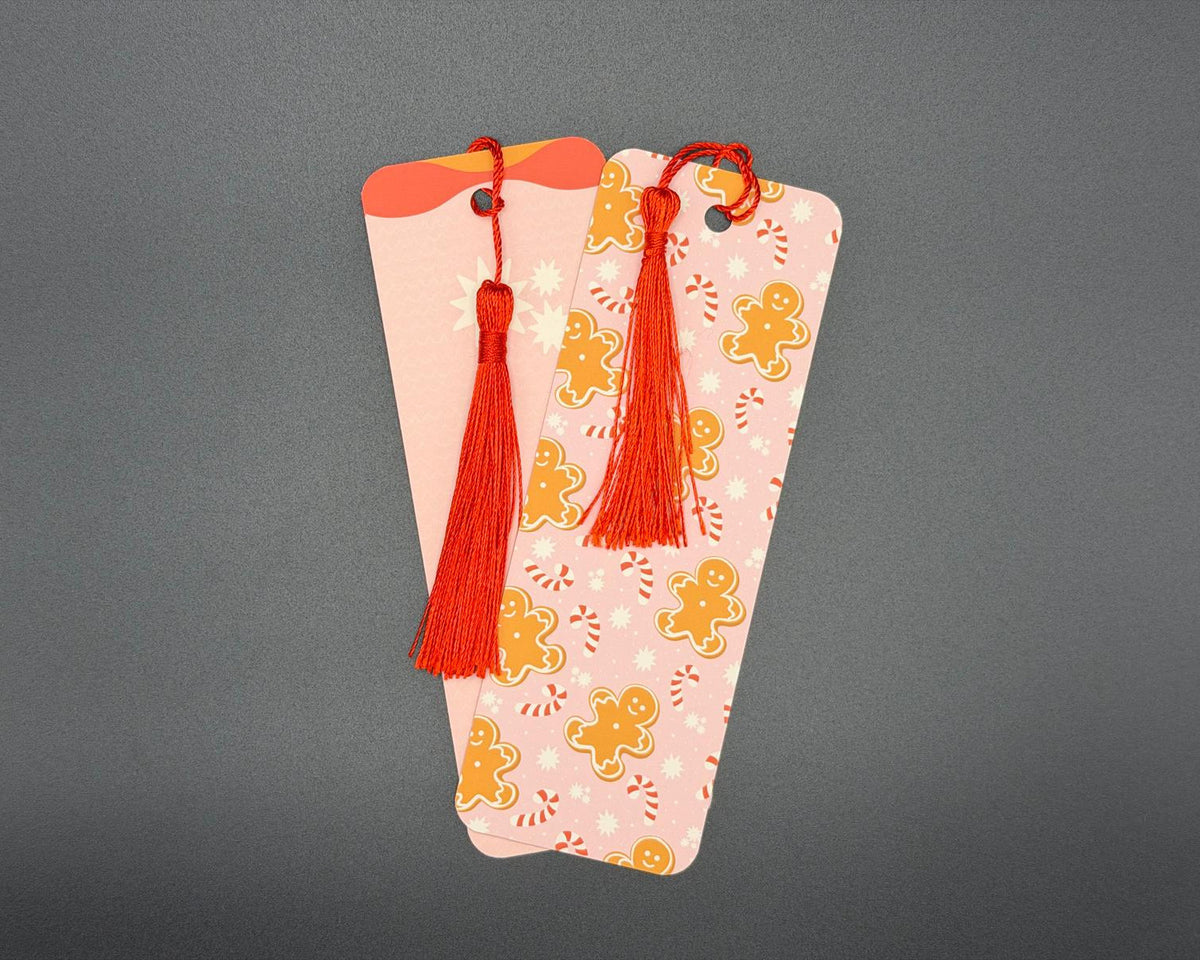 Pink gingerbread and candy cane paper bookmark with rounded corners and red fabric tassel. 