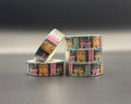 Decorative washi tape featuring colourful winter houses in yellow, pink and teal. The houses are set against a background of a night sky with tall trees. 