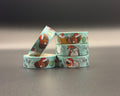 Decorative washi tapes featuring a Christmas guinea pig pattern and the words, 'ho ho ho'. The background of the tape is a light blue with white dots representing snow. There are also Brussel sprouts. 