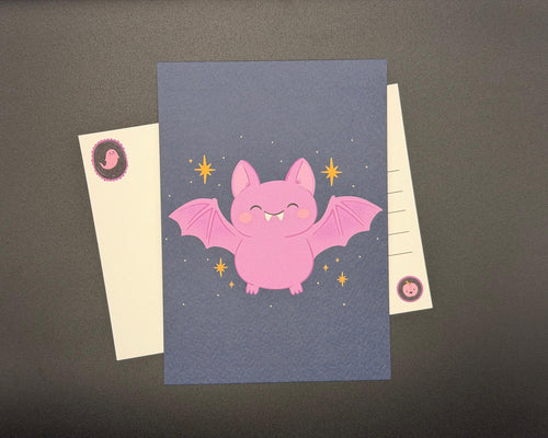 A6 Halloween postcard with cute pink bat against a night sky with ochre stars. 