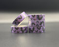 Decorative Halloween washi tape with purple background and black bats in flight. 