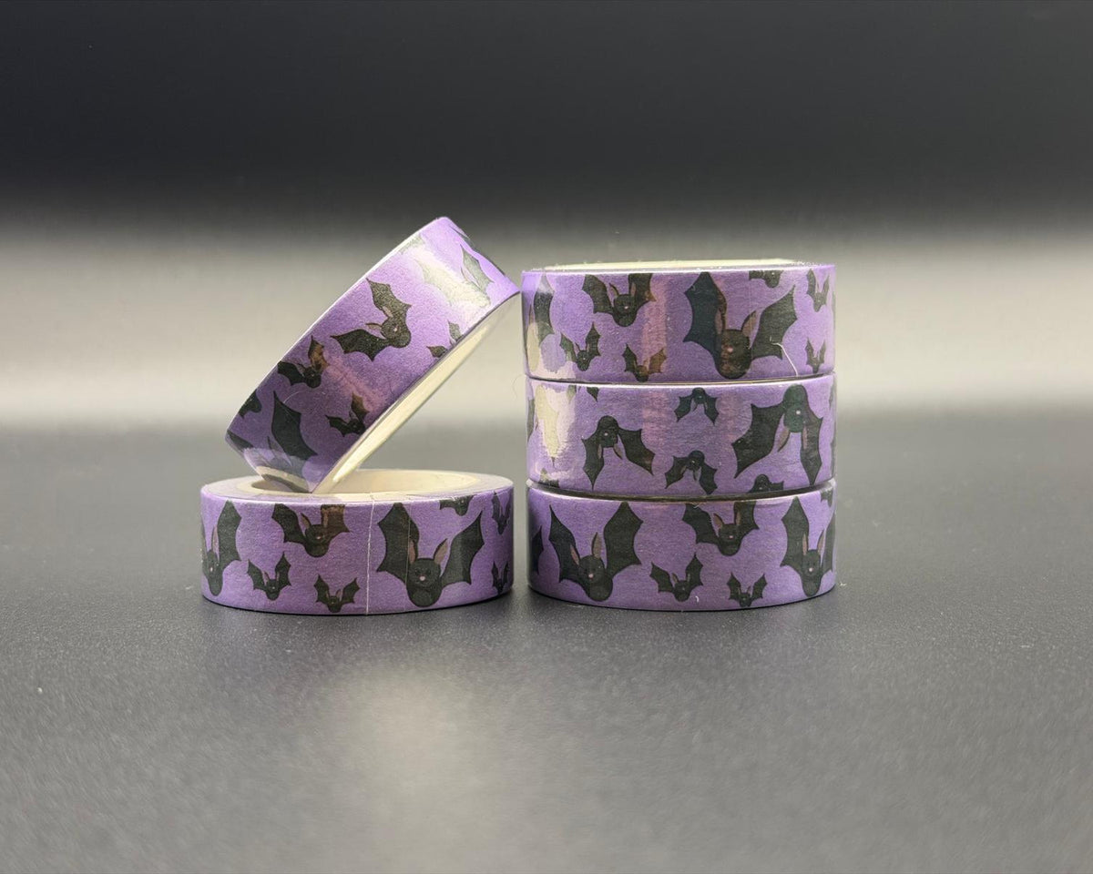 Decorative Halloween washi tape with purple background and black bats in flight. 
