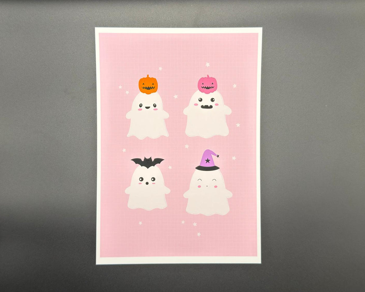 A5 Halloween art print featuring four cute ghosts. One has an orange pumpkin on their head, one has a pink pumpkin, one has a black bat and one has a purple witch's hat with a black star and banding. The background is pink with a white border. 