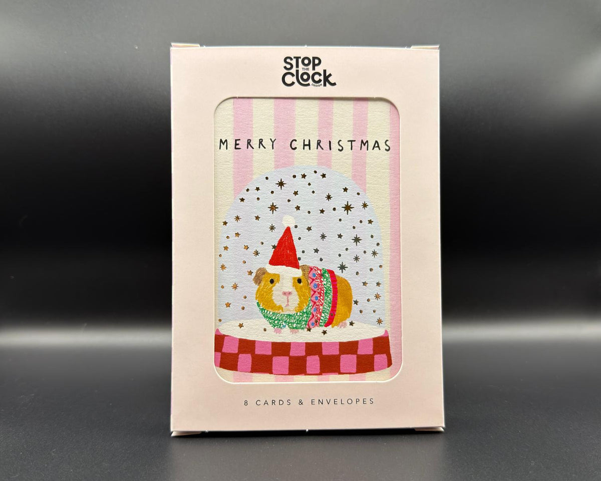 Pack of eight Christmas Cards from Stop the Clock Design. The cards feature pink and cream stripes, the words 'Merry Christmas' and a cute guinea pig in a snow globe with a pink checked base. 